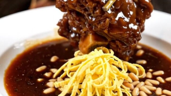 A cinematic close-up of tender Korean Galbi-Jjim braised short ribs in a glossy soy-pear glaze inside a ceramic slow cooker.