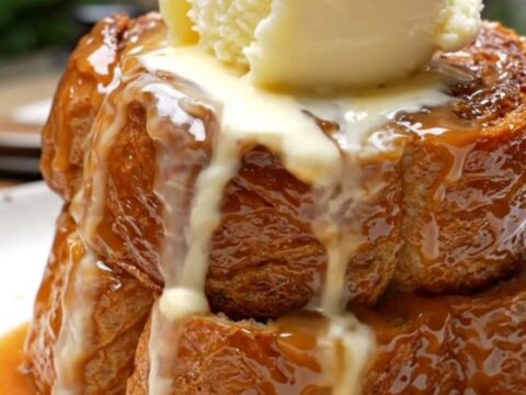 A warm, decadent Bananas Foster French toast bake in a ceramic slow cooker topped with toasted pecans.