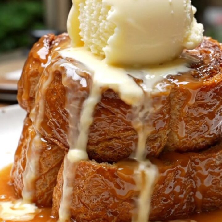 A warm, decadent Bananas Foster French toast bake in a ceramic slow cooker topped with toasted pecans.