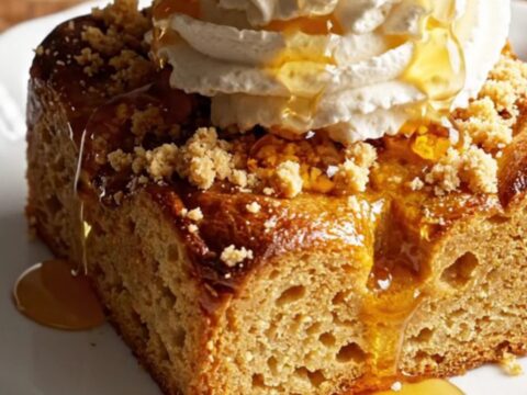 A close-up of a pumpkin spice brioche French toast casserole with a golden brown streusel topping.