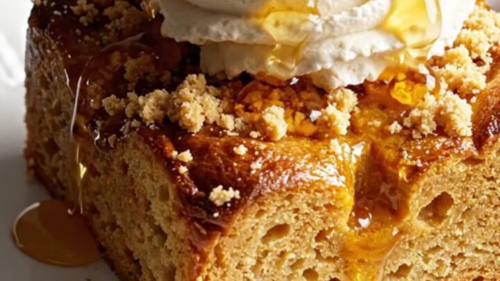 A close-up of a pumpkin spice brioche French toast casserole with a golden brown streusel topping.
