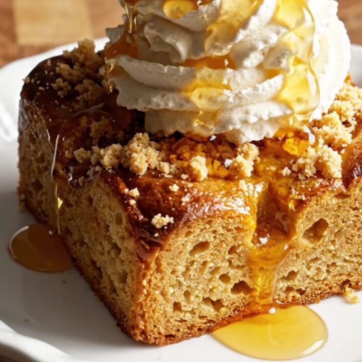 A close-up of a pumpkin spice brioche French toast casserole with a golden brown streusel topping.