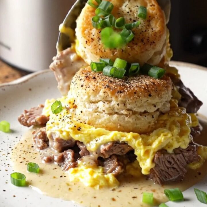 A rustic black slow cooker filled with a golden, bubbling breakfast casserole topped with green onions.