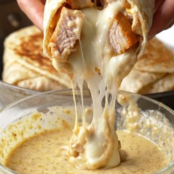 Crispy chicken alfredo wrap cut in half, showing creamy garlic parmesan sauce and melted mozzarella.