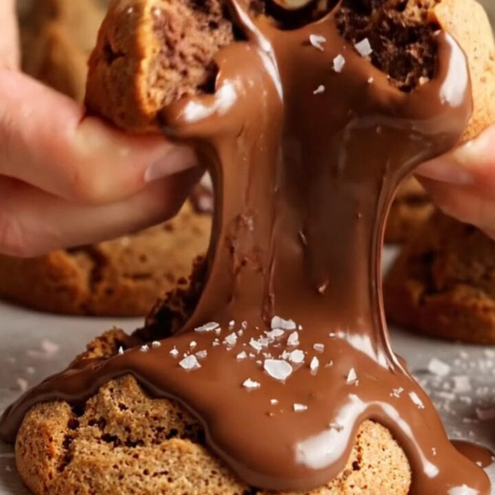 Two chocolate chunk cookies stacked, showing crispy edges and gooey melted chocolate centers