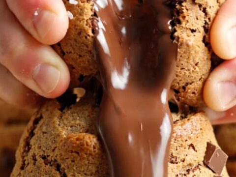 Giant cookie broken open showing molten chocolate center