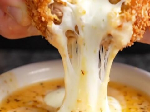 Golden brown crispy chicken potato croquettes stacked on a plate with a creamy dip