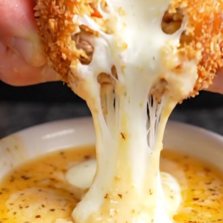 Golden brown crispy chicken potato croquettes stacked on a plate with a creamy dip