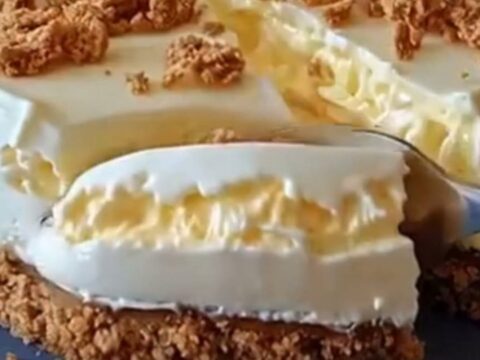 Sliced no-bake condensed milk cheesecake with crumb topping on a blue ceramic plate under warm light