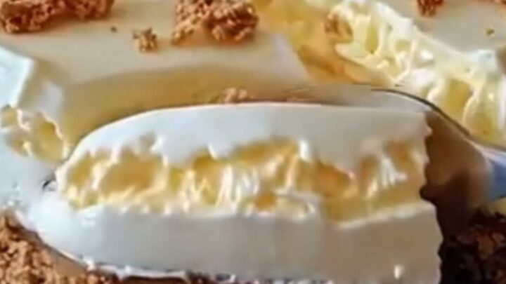 Sliced no-bake condensed milk cheesecake with crumb topping on a blue ceramic plate under warm light