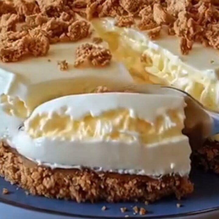 Sliced no-bake condensed milk cheesecake with crumb topping on a blue ceramic plate under warm light