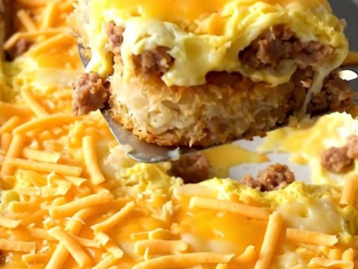 Golden hash brown patty breakfast casserole with turkey sausage and melted cheddar bubbling at the edges in a white ceramic