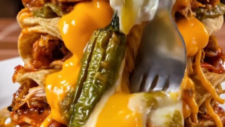 Cross-section of a four-layer stacked New Mexico green chile enchilada with melted cheddar cascading down the sides
