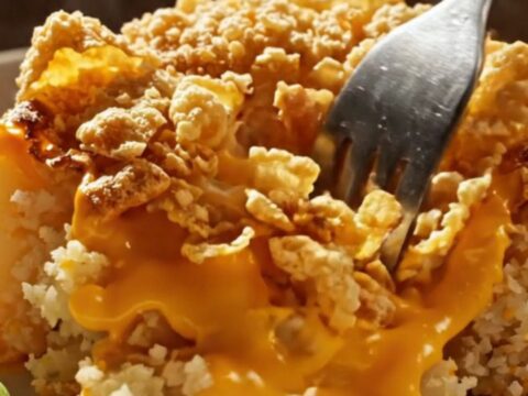 Cheesy funeral potatoes in a speckled enamel baking dish, golden cornflake crust bubbling with sharp cheddar sauce