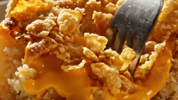Cheesy funeral potatoes in a speckled enamel baking dish, golden cornflake crust bubbling with sharp cheddar sauce