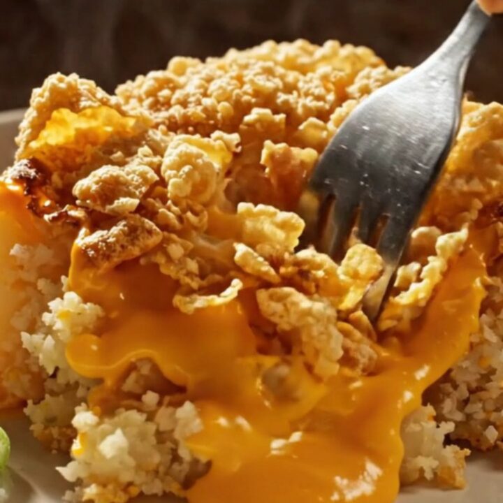 Cheesy funeral potatoes in a speckled enamel baking dish, golden cornflake crust bubbling with sharp cheddar sauce