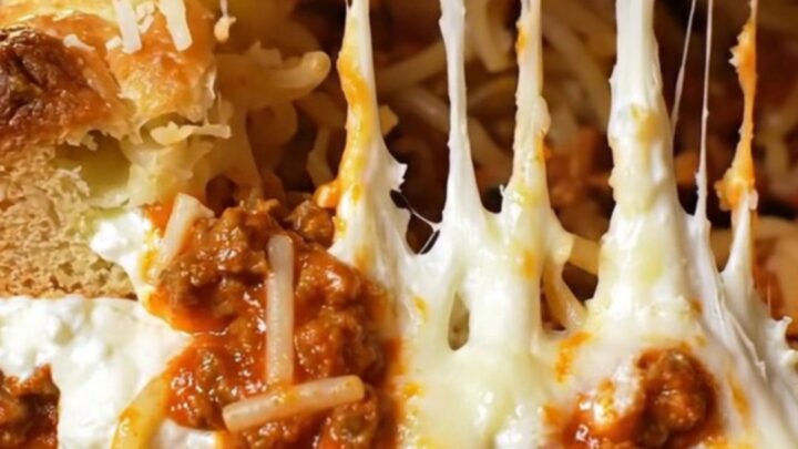 Golden-brown million-dollar baked spaghetti in a glass dish with bubbling melted mozzarella crust