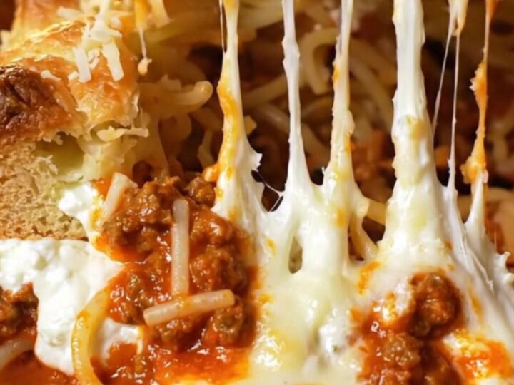 Golden-brown million-dollar baked spaghetti in a glass dish with bubbling melted mozzarella crust