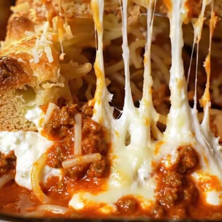 Golden-brown million-dollar baked spaghetti in a glass dish with bubbling melted mozzarella crust
