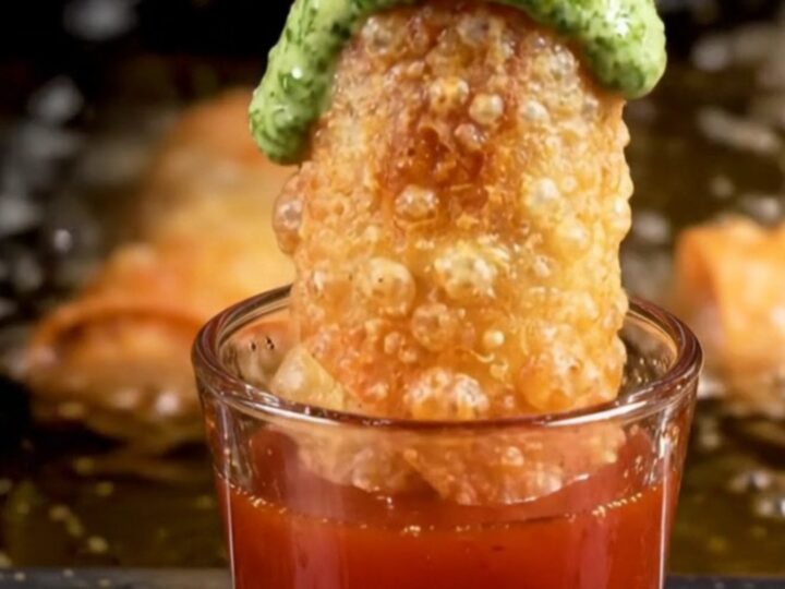 Diagonally sliced crispy birria egg roll pulled open to show braised beef and melted pepper jack