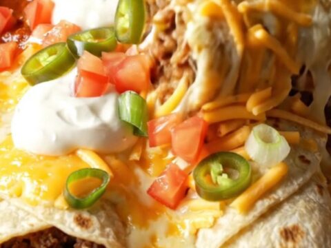 A baked enchilada-style beef burrito lifted from a bubbling 9x13 dish