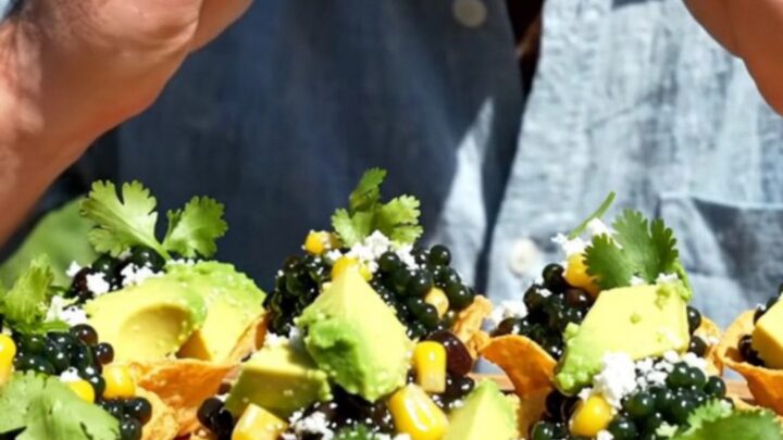 Mini tostada cups mounded with colorful cowboy caviar, diced avocado, and crumbled cotija cheese on a serving platter