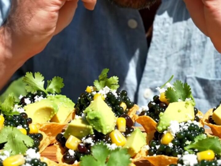 Mini tostada cups mounded with colorful cowboy caviar, diced avocado, and crumbled cotija cheese on a serving platter