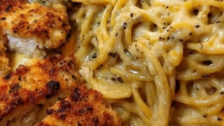 Crispy parmesan-crusted chicken slices over a mound of glossy cheesy spaghetti in a warm skillet