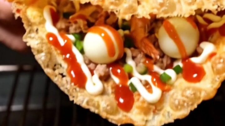 Crispy Vietnamese rice paper pizza folded in half, blistered golden and zigzagged with chili sauce and mayonnaise on a board
