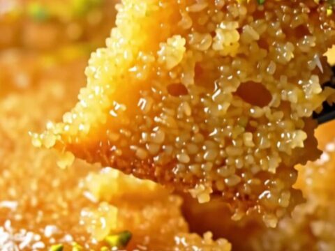 Golden Revani semolina cake with lemon syrup, topped with crushed pistachios and coconut