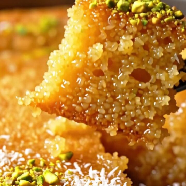 Golden Revani semolina cake with lemon syrup, topped with crushed pistachios and coconut