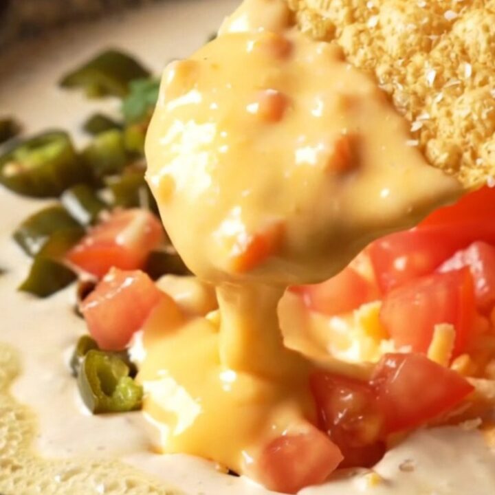 Glossy smoked gouda and Hatch green chile queso in a cast-iron skillet, a tortilla chip lifting a thick golden ribbon