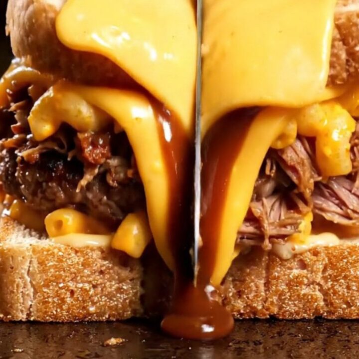 Texas toast patty melt cut in half showing layers of smash patty, pulled pork, mac and cheese, and melted colby jack