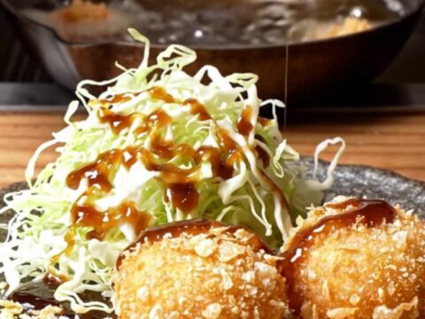 Golden fried wagyu potato korokke sliced in half, steam rising from the creamy filling