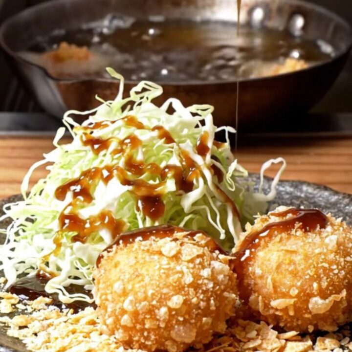 Golden fried wagyu potato korokke sliced in half, steam rising from the creamy filling