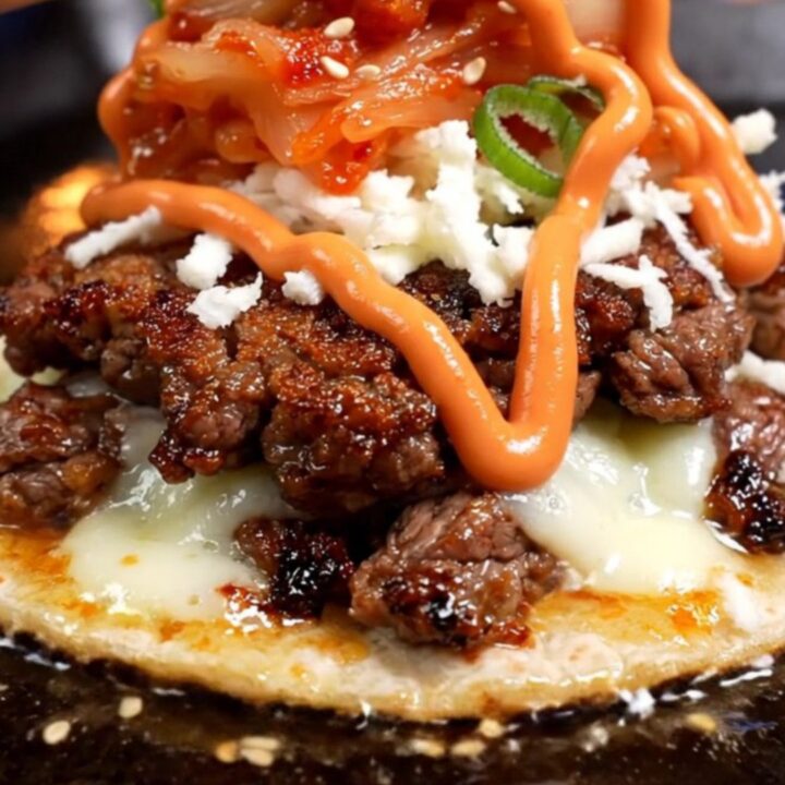 Korean bulgogi smash taco with dark caramelized beef crust, melted mozzarella, red kimchi