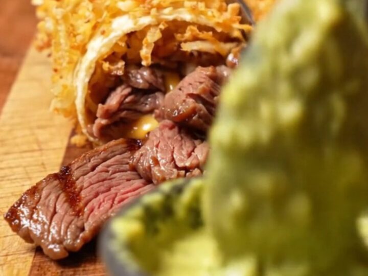 Hashbrown-crusted carne asada wrap sliced diagonally, showing melted pepper jack
