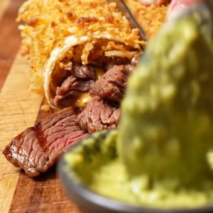 Hashbrown-crusted carne asada wrap sliced diagonally, showing melted pepper jack