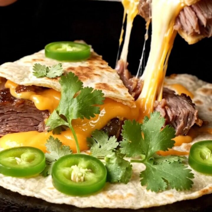 Golden smoked brisket quesadilla wedges stacked on a board, melted cheese pulling in strands