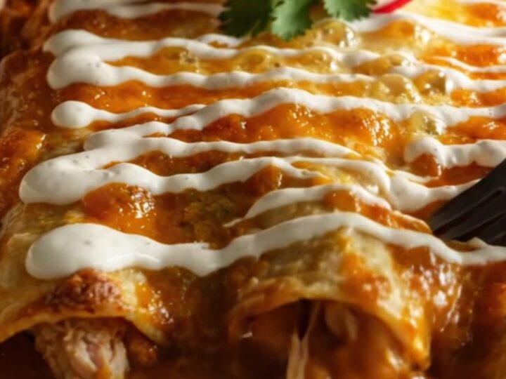 Baking dish of chicken enchiladas verdes in glossy green poblano sauce with melted Chihuahua cheese and charred corn