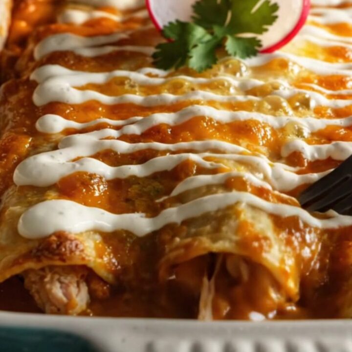 Baking dish of chicken enchiladas verdes in glossy green poblano sauce with melted Chihuahua cheese and charred corn