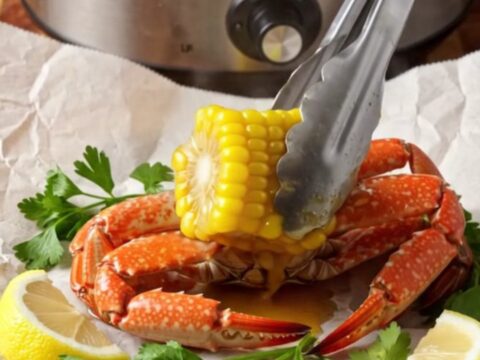 Steaming Cajun seafood boil with crab clusters, shrimp, corn ribs and potatoes glazed in red-gold garlic butter on butcher