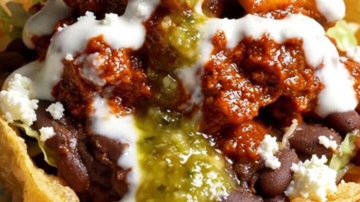 Crispy handmade sope with pinched golden rim overflowing with refried black beans, chicken tinga, lettuce
