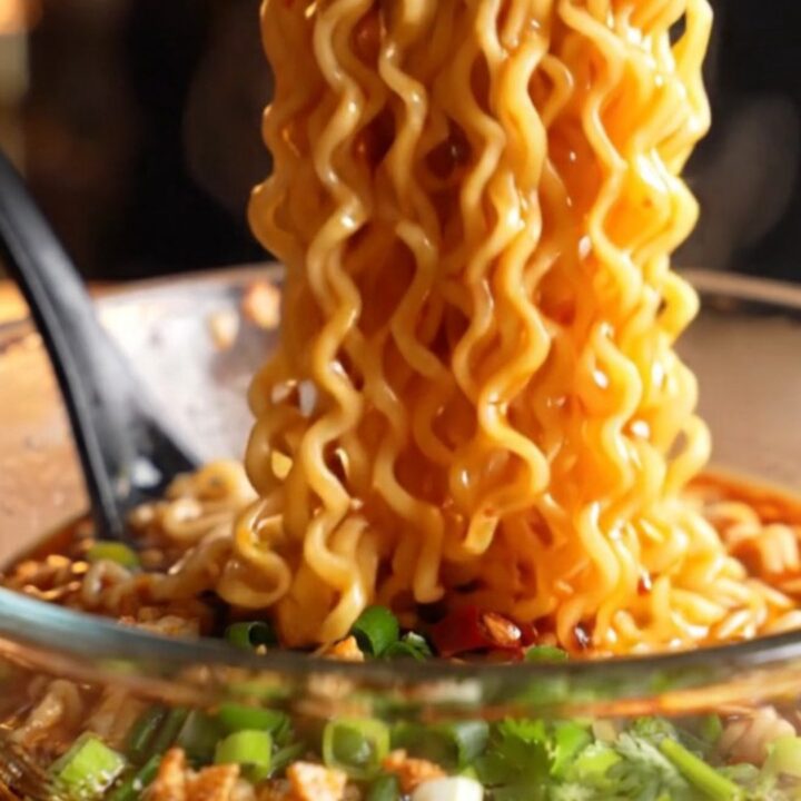 Glossy spicy garlic chili oil ramen noodles in a bowl with chopped chilies and scallions