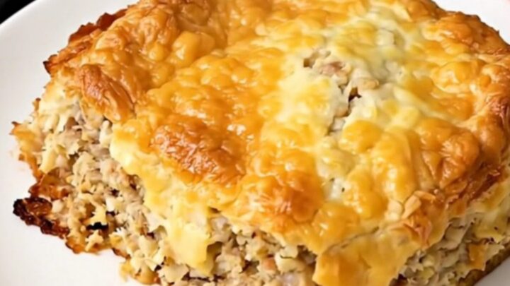 Golden crockpot sausage hash brown breakfast casserole steaming in a black oval slow cooker on a white countertop