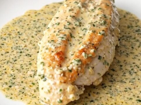 Slow cooker angel chicken: whole chicken breasts in thick creamy Italian herb sauce in a black ceramic insert on a quartz