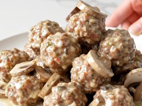Turkey meatballs and sliced mushrooms coated in thick creamy ranch sauce in a black slow cooker insert