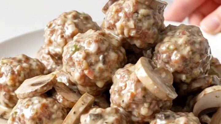Turkey meatballs and sliced mushrooms coated in thick creamy ranch sauce in a black slow cooker insert
