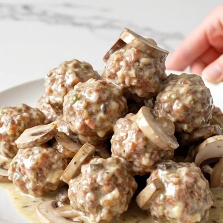 Turkey meatballs and sliced mushrooms coated in thick creamy ranch sauce in a black slow cooker insert