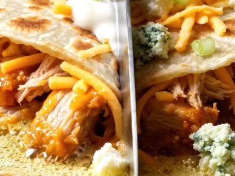 Golden buffalo chicken quesadilla wedge with a long stretch of melted mozzarella and cheddar, drizzled with ranch